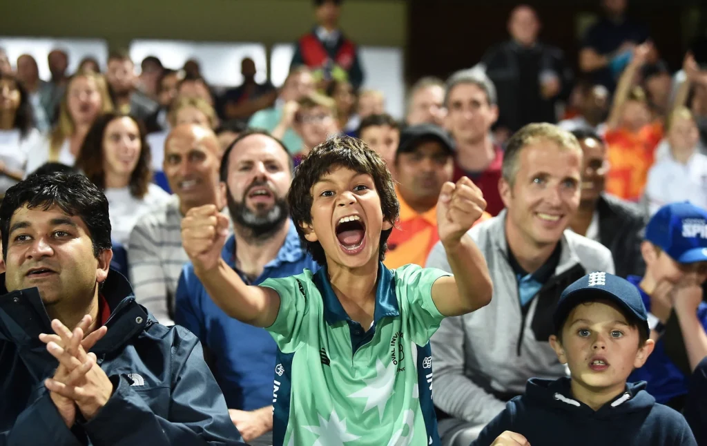 A crowd celebrating at a cricket match