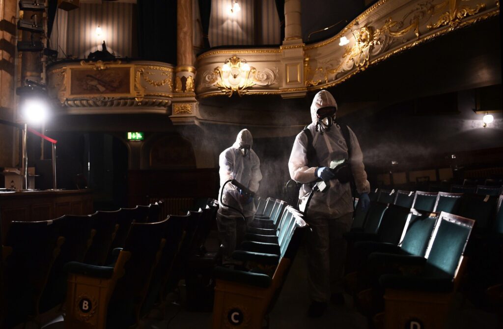 Theatre sanitisation procedure with workers in PPE.