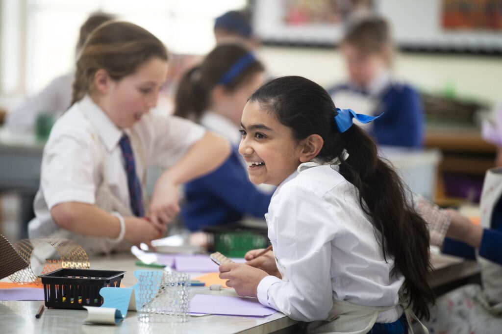 A joyful girl in a school art class, engaged in creative activities.