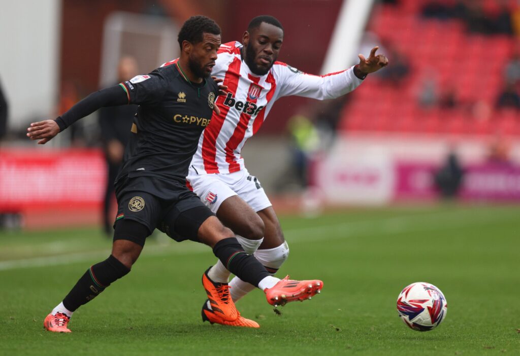 Action shot from the football match between Stoke City and Queens Park Rangers, showcasing players competing for the ball.