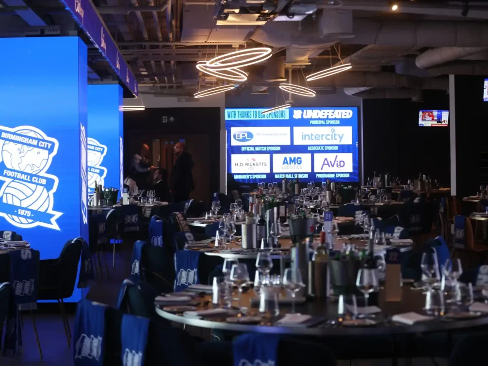 Elegant dining setup at Birmingham City Football Club event space with blue decor.