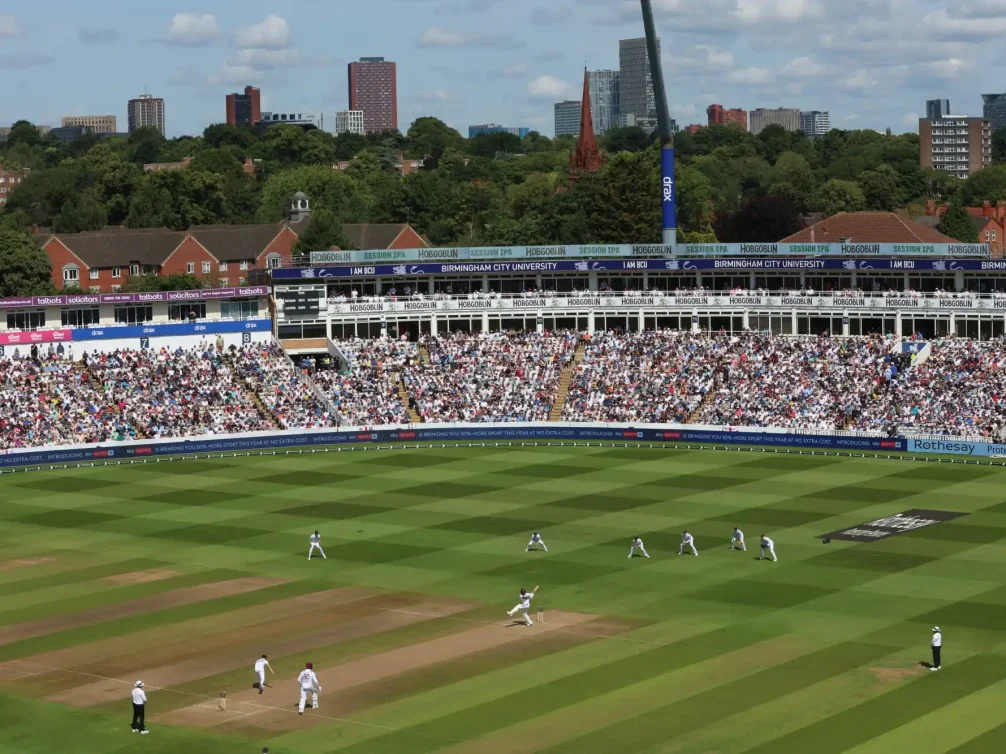 A vibrant cricket match at Birmingham's iconic stadium with a packed crowd.