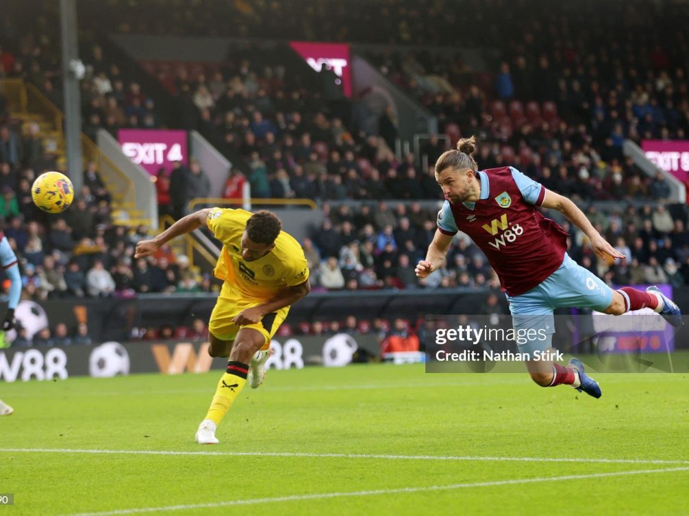 Dramatic moment in a football match between Brentford and Burnley, showcasing players in action.