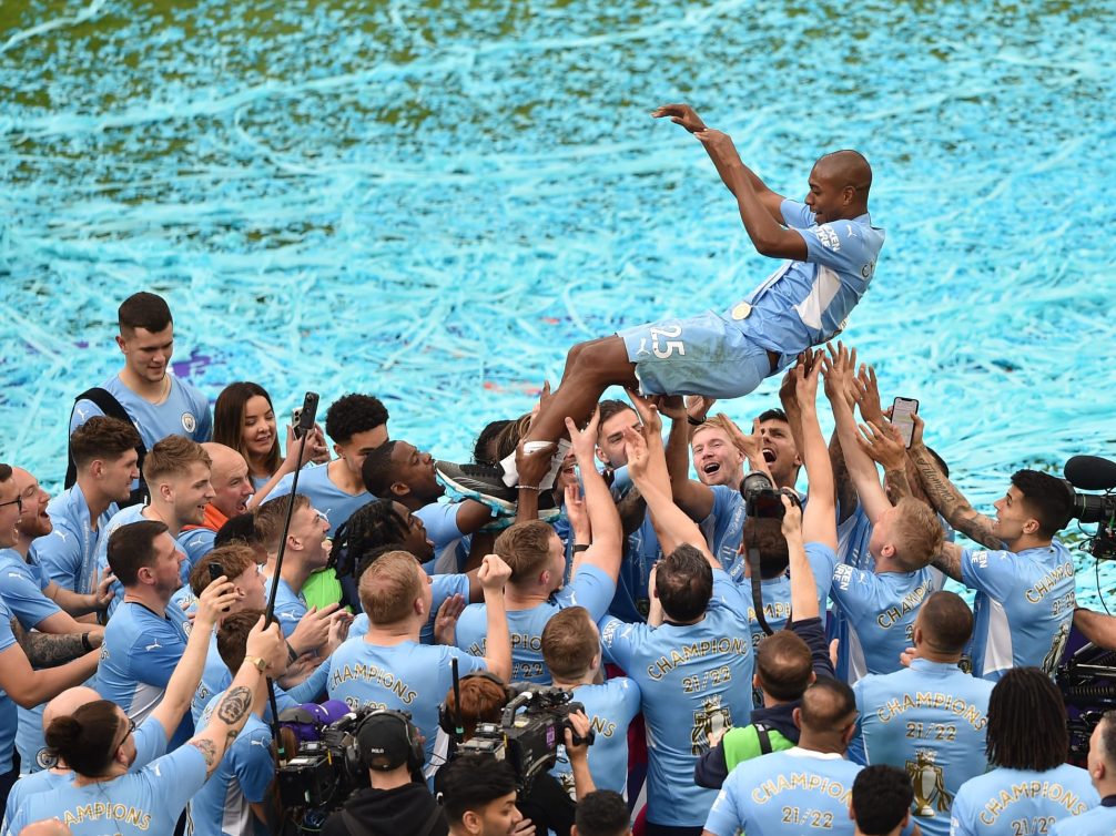 Manchester City players celebrating their championship victory with confetti.