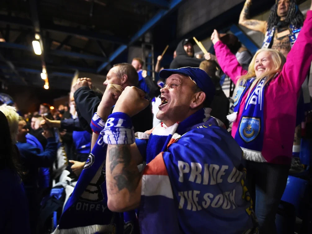 Portsmouth FC fans passionately cheering in the stands.
