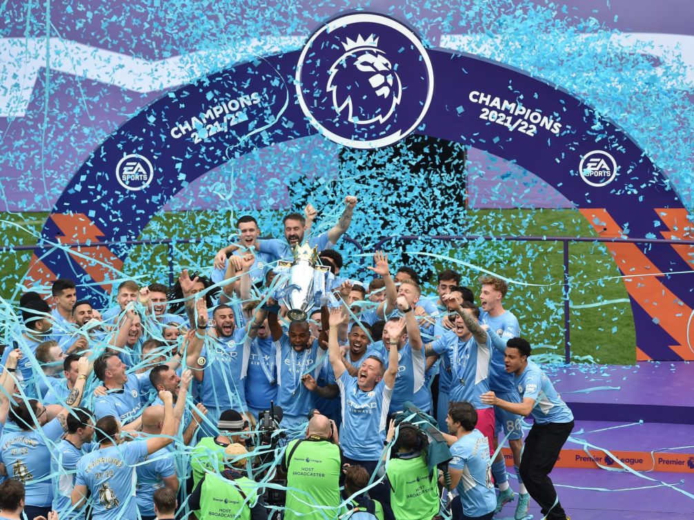 Manchester City players celebrating their Premier League 2021/22 championship victory with confetti.