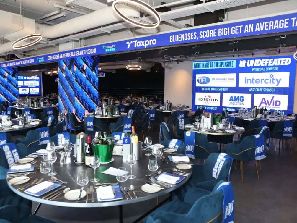 Decorated venue for a sponsorship event showcasing branding and elegant table settings.